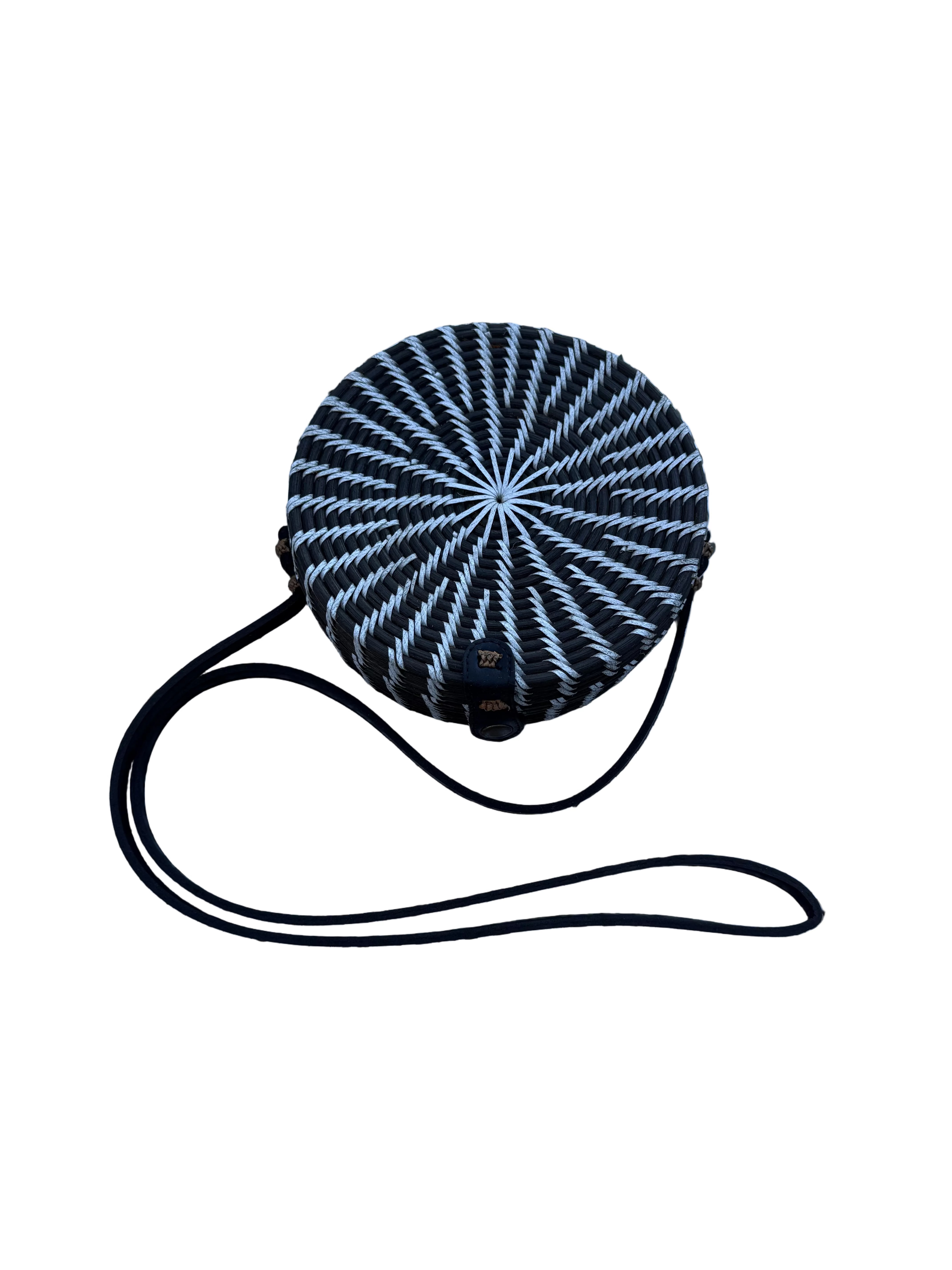 Black and white circular object with a strap on a textured blue background