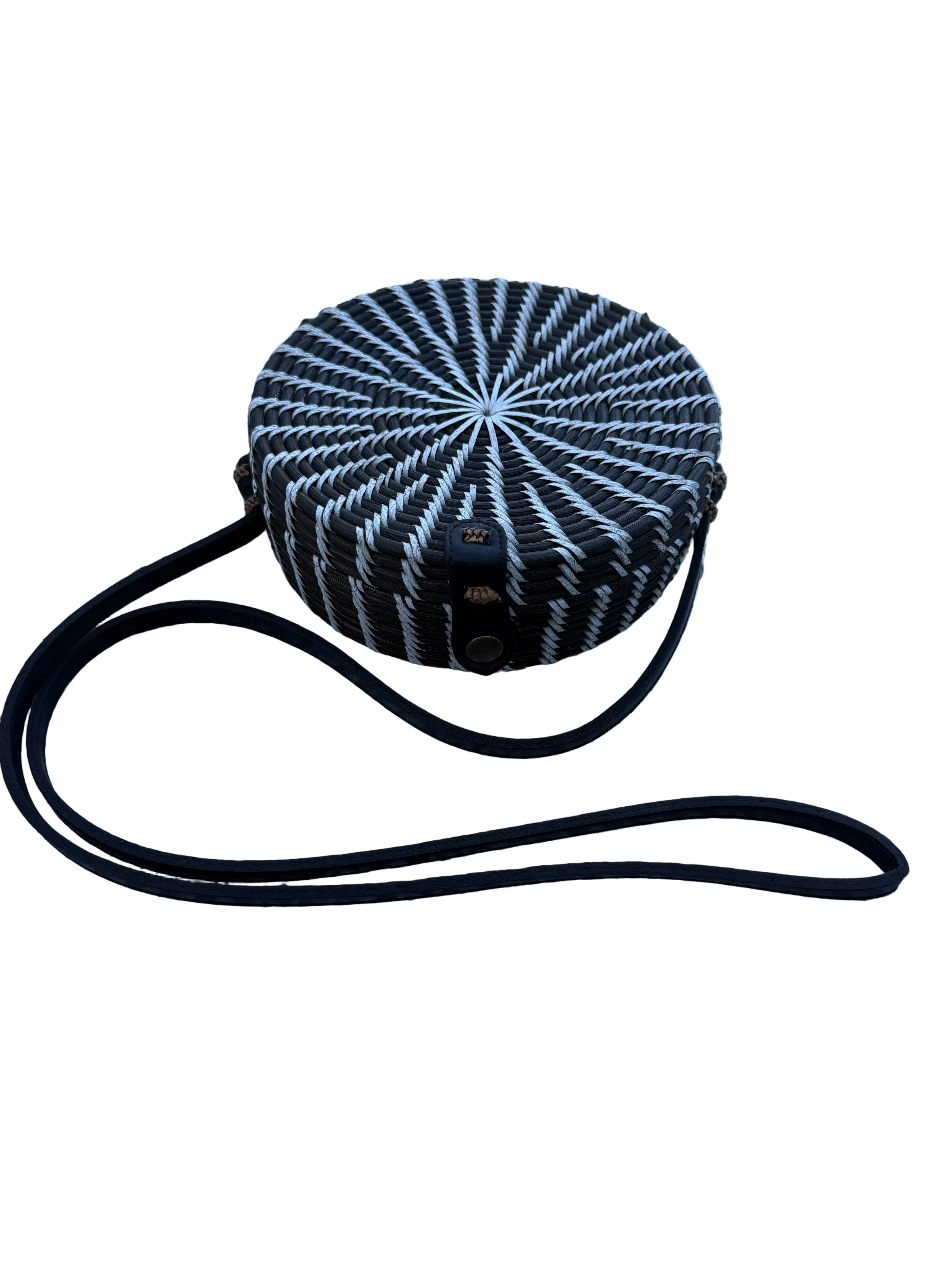 Black and white patterned handbag with a strap on a white mesh surface